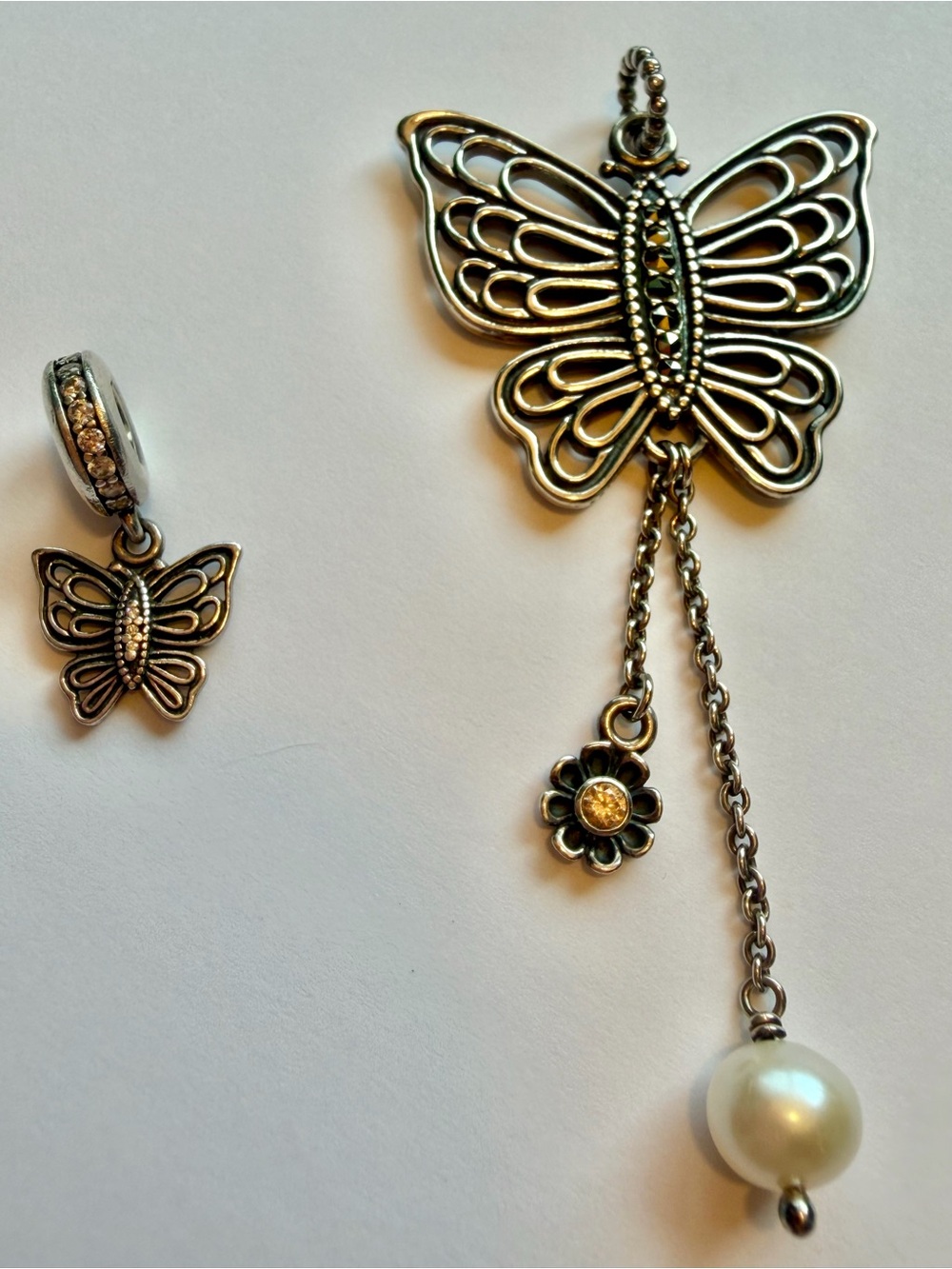Pandora Butterfly Love Takes Flight silver pendant and matching bracelet dangle.